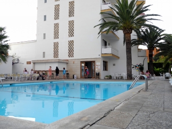 Pool mit Hotelgebäude dahinter.