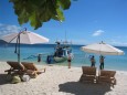 Sonnenliegen, Schirme und ein Boot am White Beach auf Boracay